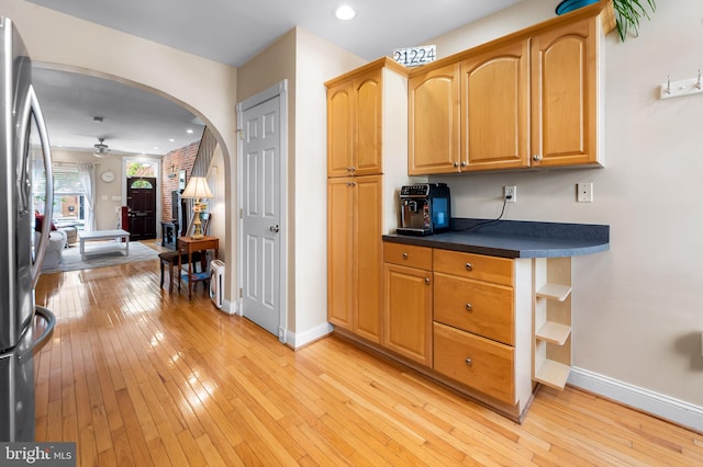 642 S Decker Ave, Baltimore, MD 21224 - kitchen with ceiling fan, arched walkways, light wood-style flooring, baseboards, and stainless steel refrigerator with ice dispenser