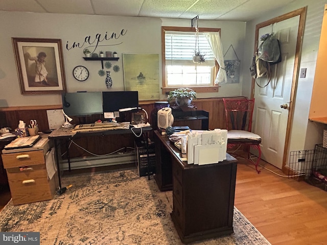 office space with a drop ceiling and wood finished floors
