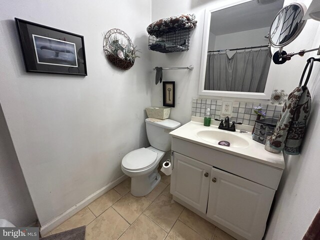 bathroom with decorative backsplash, a shower with shower curtain, baseboards, toilet, and vanity