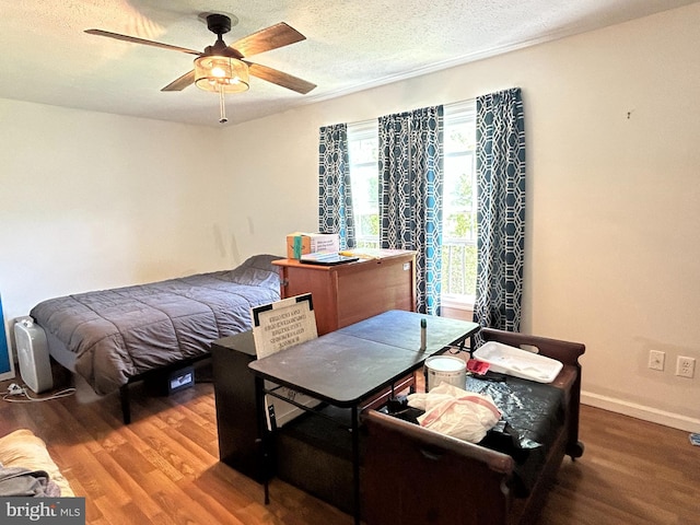 bedroom with a textured ceiling, a ceiling fan, and wood finished floors