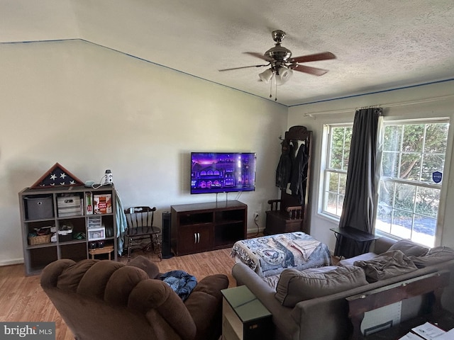 living room featuring a textured ceiling, wood finished floors, and a ceiling fan