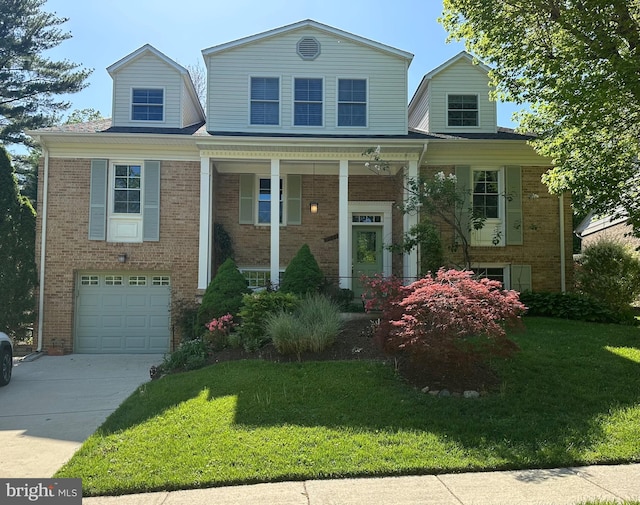view of front of home with driveway, a front yard, brick siding, and a garage