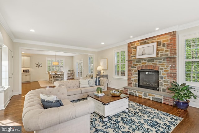 living area with a fireplace, wood finished floors, and ornamental molding