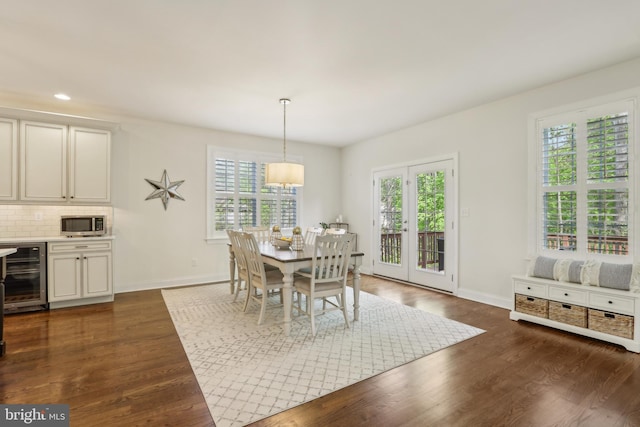 dining room with wine cooler, a wealth of natural light, and dark wood finished floors