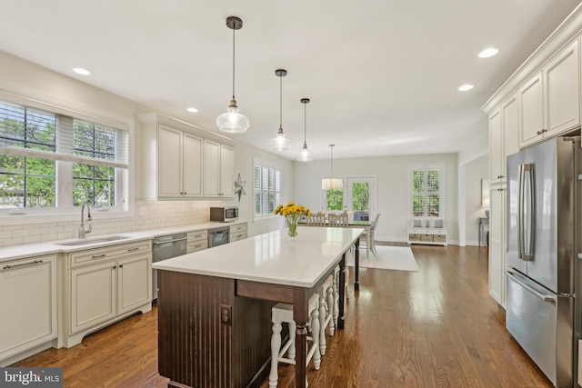 kitchen featuring recessed lighting, stainless steel appliances, backsplash, light countertops, and dark wood finished floors