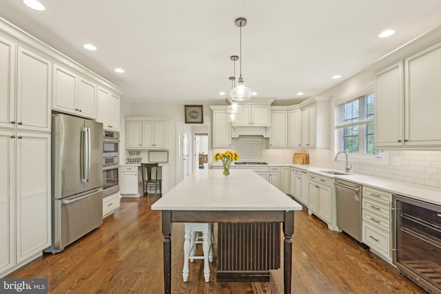 kitchen featuring appliances with stainless steel finishes, wine cooler, backsplash, and a sink