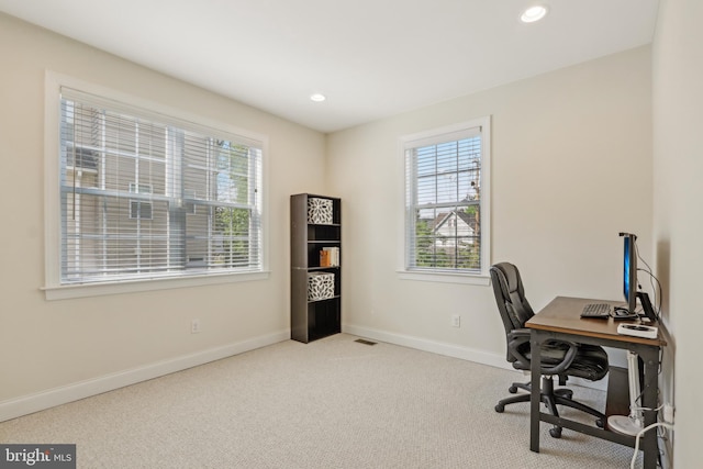 carpeted office space with a healthy amount of sunlight, recessed lighting, visible vents, and baseboards