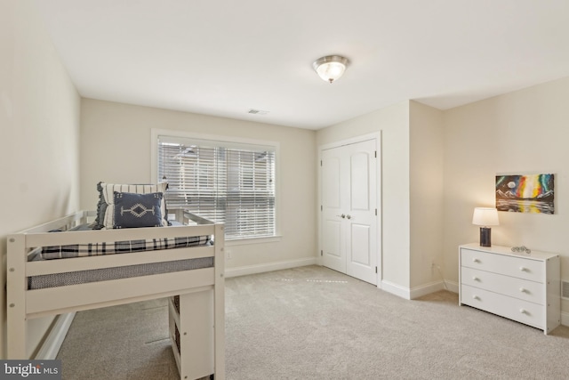interior space featuring light colored carpet, visible vents, a closet, and baseboards