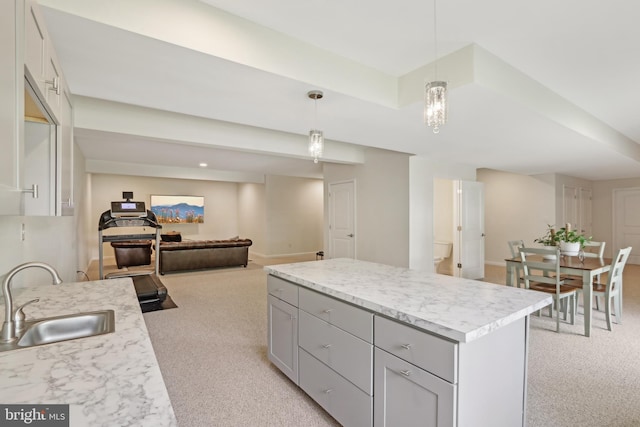 kitchen featuring light colored carpet, light countertops, gray cabinets, and a sink