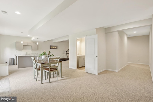 dining space with light colored carpet, visible vents, and baseboards