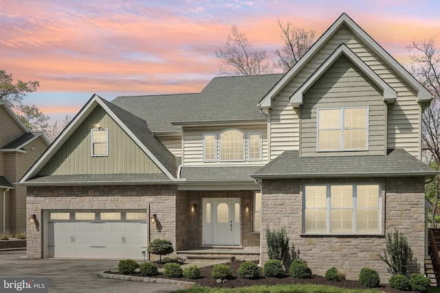 craftsman inspired home with driveway, roof with shingles, board and batten siding, and stone siding