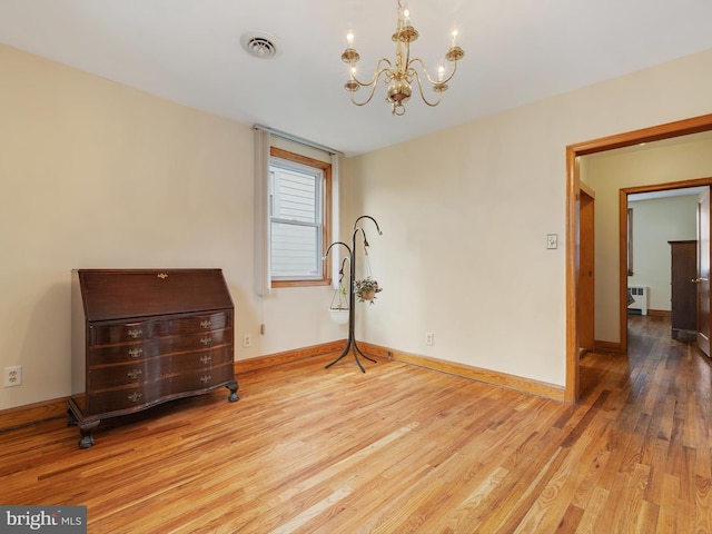 unfurnished bedroom featuring wood finished floors, a chandelier, radiator, baseboards, and visible vents