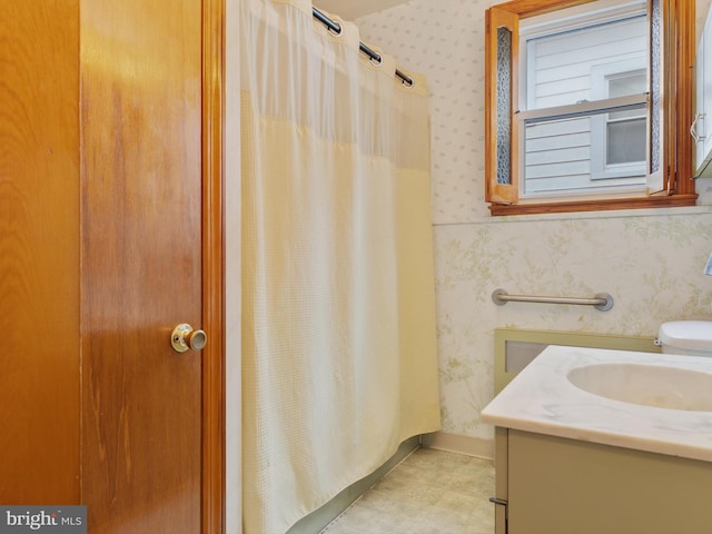 full bath featuring vanity, a shower with shower curtain, and wallpapered walls