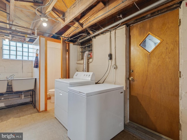 laundry area featuring a sink, washing machine and clothes dryer, laundry area, and light floors