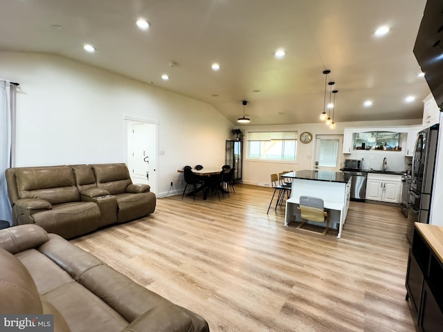 living area with recessed lighting, baseboards, vaulted ceiling, and light wood-type flooring