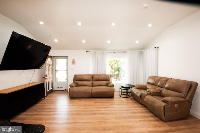 living room with recessed lighting, light wood-style flooring, and lofted ceiling