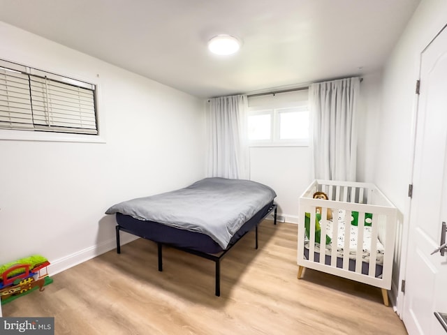 bedroom with baseboards and light wood finished floors