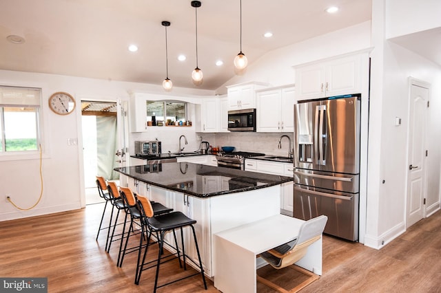 kitchen with appliances with stainless steel finishes, white cabinets, and tasteful backsplash