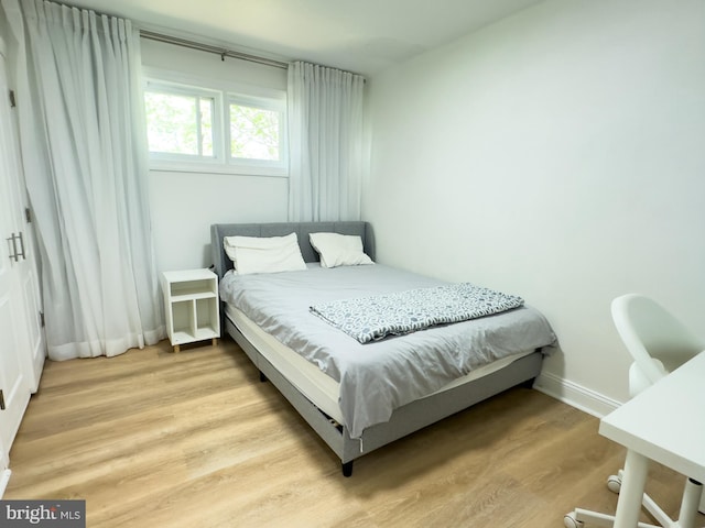 bedroom featuring light wood-style floors and baseboards