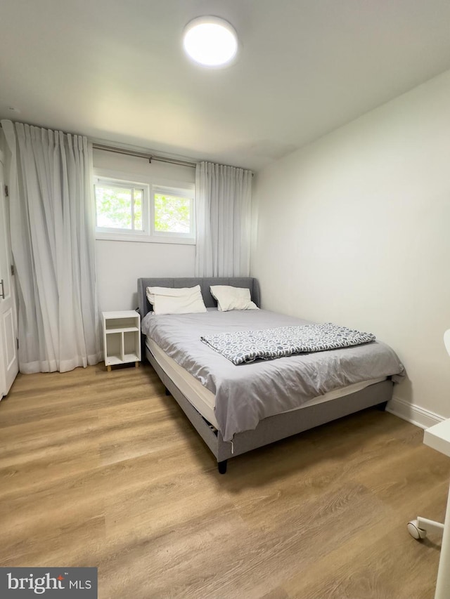 bedroom with baseboards and wood finished floors