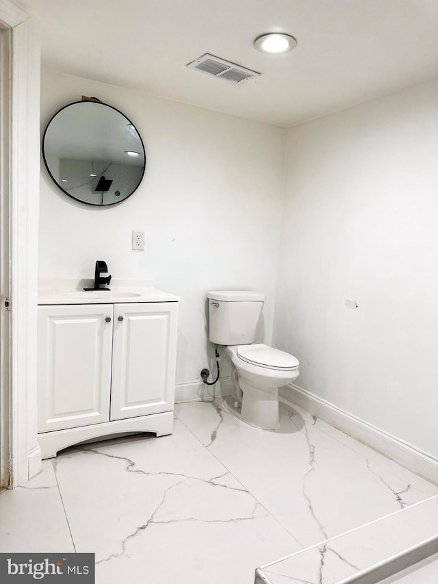 bathroom with visible vents, vanity, marble finish floor, toilet, and baseboards