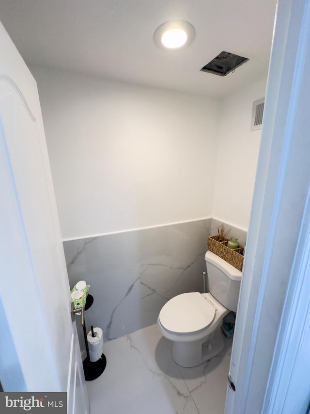 bathroom with visible vents, marble finish floor, and toilet