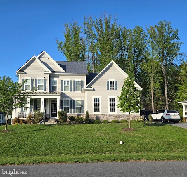 view of front of house with a front yard, a porch, and stone siding