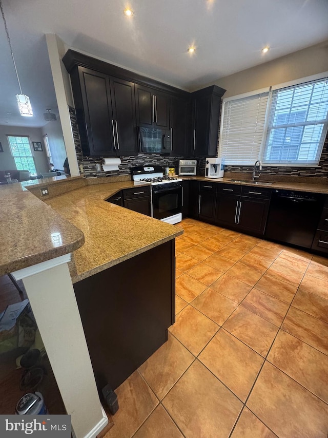 8800 Fenimore Pl, Bristow, VA 20136 - kitchen with black appliances, dark cabinetry, a peninsula, backsplash, and a sink