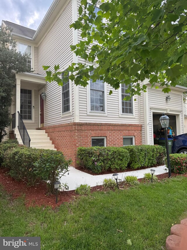 8800 Fenimore Pl, Bristow, VA 20136 - view of home's exterior featuring brick siding, a garage, and a lawn