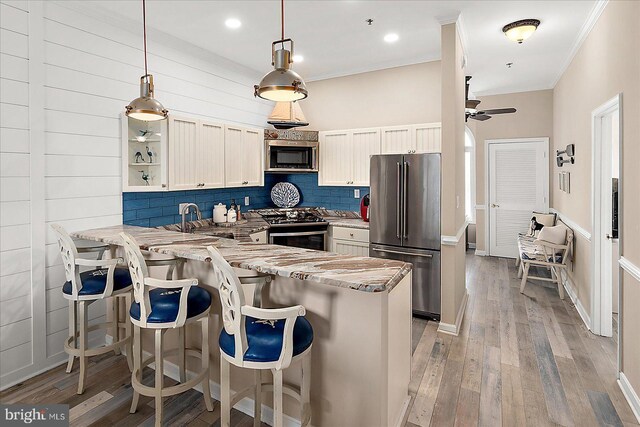 201 S Heron Dr Unit 9B, Ocean City, MD 21842 - kitchen with ceiling fan, backsplash, a peninsula, ornamental molding, and stainless steel appliances