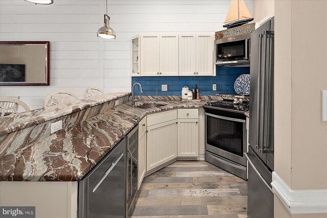 201 S Heron Dr Unit 9B, Ocean City, MD 21842 - kitchen with light wood-style floors, a sink, stone counters, and appliances with stainless steel finishes