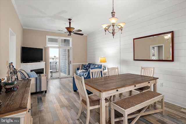 201 S Heron Dr Unit 9B, Ocean City, MD 21842 - dining area with crown molding, wood walls, ceiling fan with notable chandelier, baseboards, and dark wood-style floors