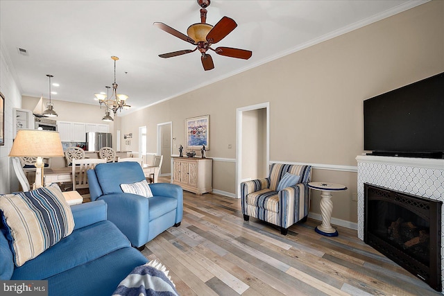 201 S Heron Dr Unit 9B, Ocean City, MD 21842 - living area featuring crown molding, light wood-style floors, ceiling fan with notable chandelier, and a fireplace