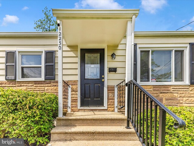property entrance with stone siding