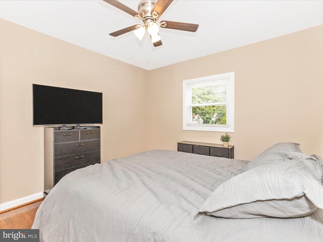 bedroom featuring a ceiling fan, baseboards, and wood finished floors
