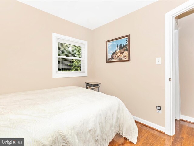 bedroom with baseboards and wood finished floors