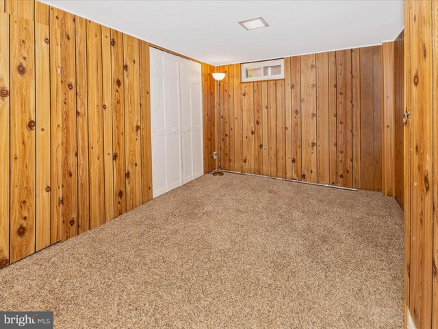 finished below grade area with carpet flooring and wooden walls