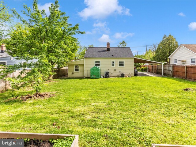 rear view of house with a lawn, a chimney, and a fenced backyard