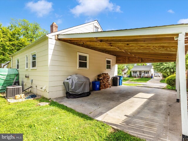 view of home's exterior with central air condition unit, a lawn, a chimney, and a carport