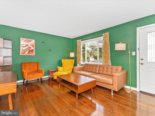 living area with baseboards and wood finished floors