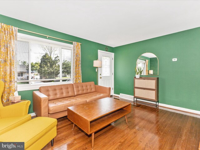 living area with baseboards and wood finished floors