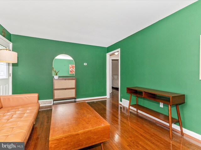 living area with baseboards and wood finished floors