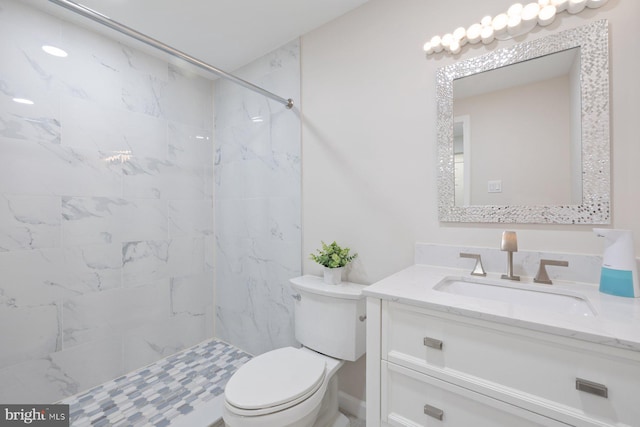 full bath featuring vanity, toilet, and a marble finish shower