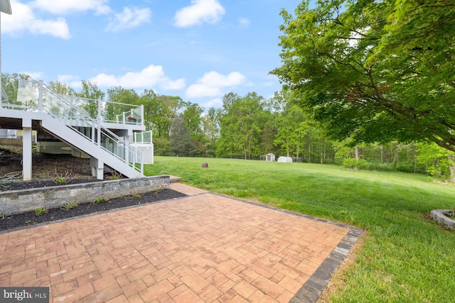 view of patio featuring an outbuilding, a storage shed, and stairway