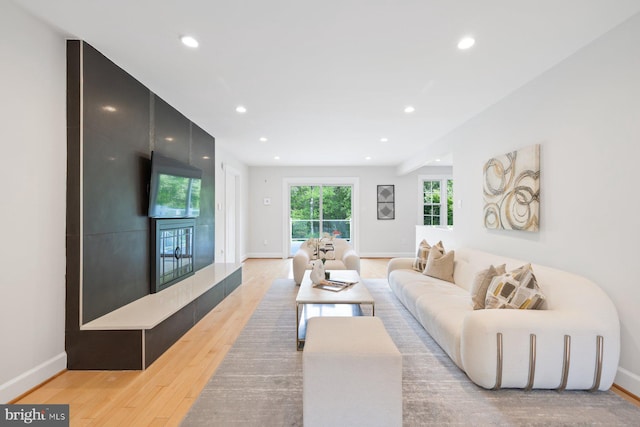 living room featuring recessed lighting, baseboards, and light wood-style floors