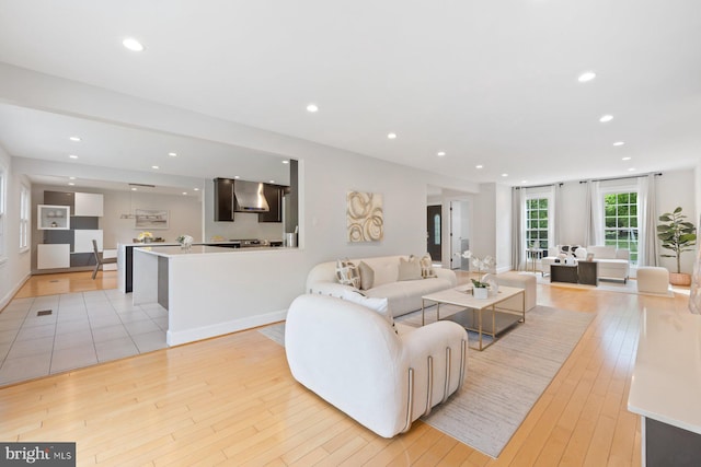 living area featuring recessed lighting, light wood finished floors, and baseboards