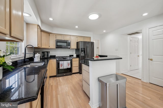 kitchen featuring a sink, light brown cabinets, stainless steel appliances, and light wood-type flooring