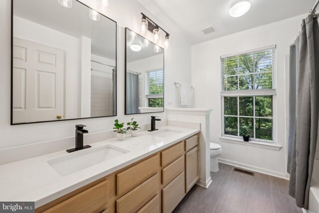 bathroom featuring visible vents, a sink, and toilet