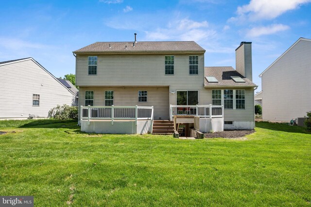 rear view of property featuring central AC unit, a wooden deck, a yard, and a chimney