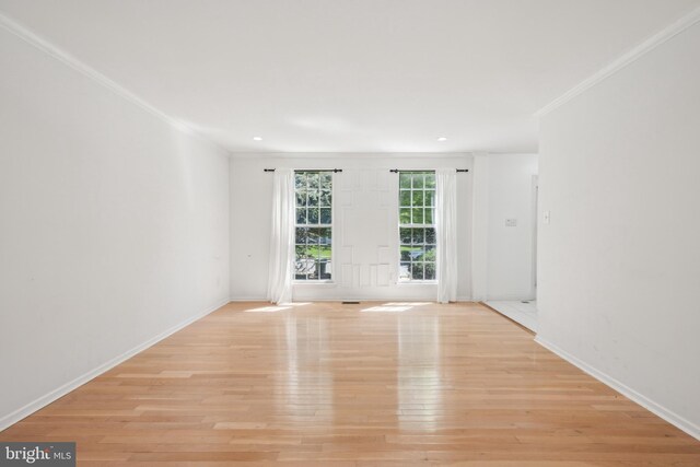 empty room with baseboards, ornamental molding, light wood-style flooring, and recessed lighting